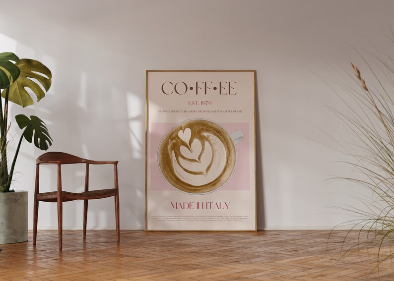 May include: A poster with a minimalist design featuring a cup of coffee with latte art. The poster is framed in a light wood frame and has the text "COFFEE EST. 1979 MADE IN ITALY" on it.