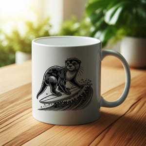Puede incluir: Una taza de cer&aacute;mica blanca con una ilustraci&oacute;n en blanco y negro de una nutria montando una tabla de surf sobre una ola. La nutria est&aacute; mirando hacia el lado derecho de la taza.