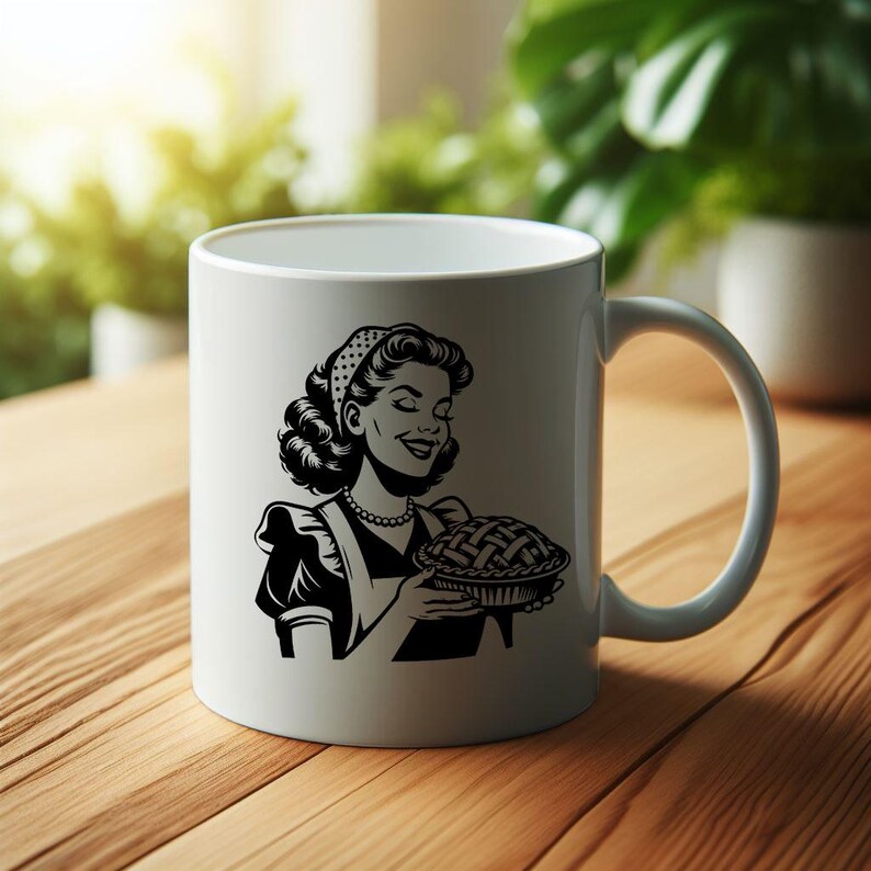 May include: White ceramic mug with a black and white illustration of a woman holding a pie. The woman is wearing a headband and an apron.