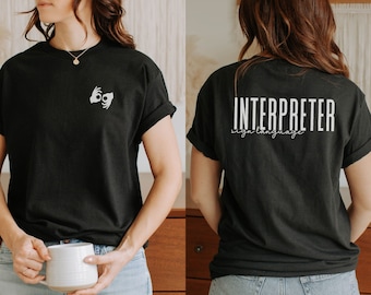 May include: Black t-shirt with the sign language symbol for "I" on the front and the text "INTERPRETER sign language" on the back.