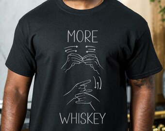 May include: Black t-shirt with the text "MORE" and a sign language hand gesture for "more". Below the text is the word "WHISKEY" with a sign language hand gesture for "whiskey".