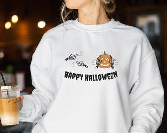 May include: White sweatshirt with a black and white graphic of a pumpkin with skeleton hands covering its eyes. The text "Happy Halloween" is printed below the graphic.