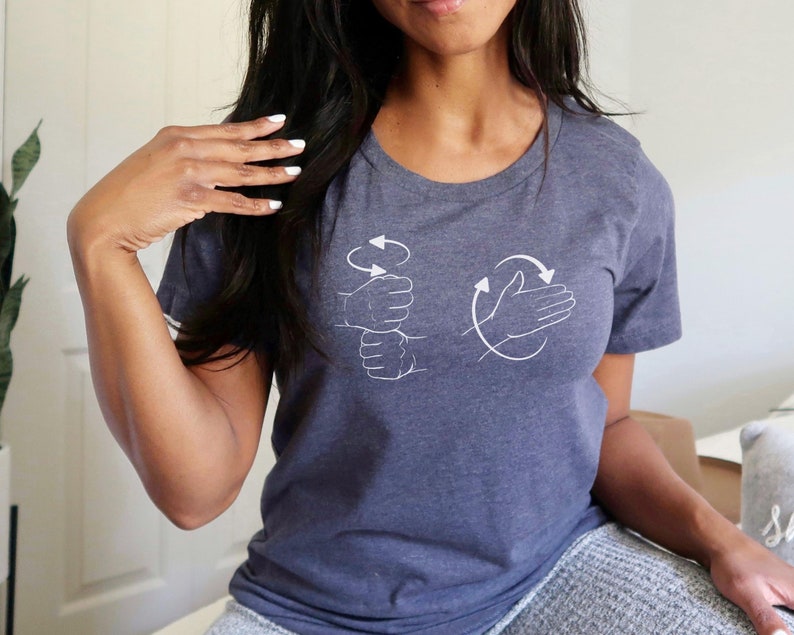 May include: A dark gray t-shirt with a white graphic of two hands demonstrating the ASL sign for "I love you".