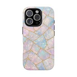 May include: A smartphone case with a mosaic design. The case features a pattern of irregular, iridescent tiles in shades of white, pink, and blue, separated by gold-colored lines. The camera module has three lenses and a flash.