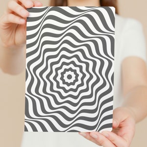 May include: A black and white optical illusion print with a swirling pattern. The print is on a white background and has a starburst design in the center.