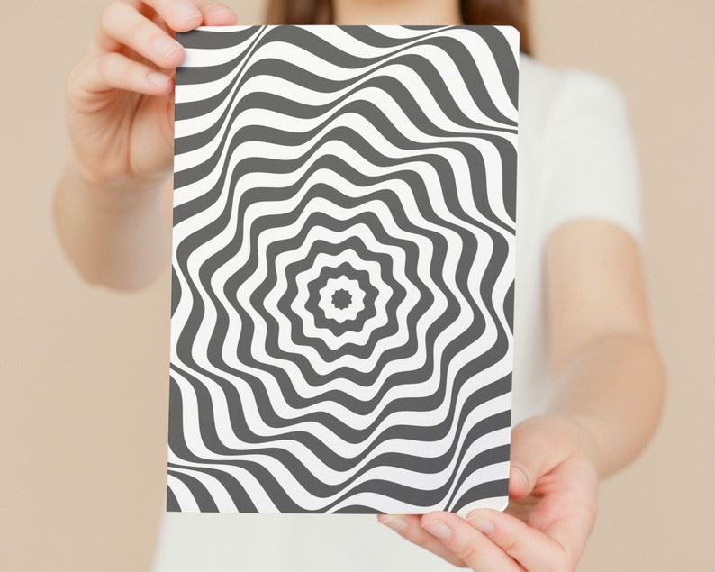 May include: A black and white optical illusion print with a swirling pattern. The print is on a white background and has a starburst design in the center.
