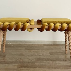 May include: A wooden bench with a woven rope design and yellow velvet cushions. The bench has twisted legs and a simple, modern design.