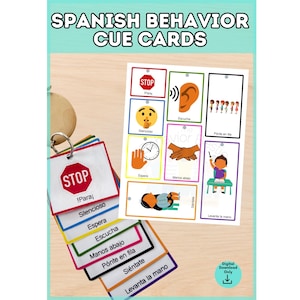 May include: A set of Spanish behaviour cue cards featuring colourful borders and illustrations. The cards display icons for actions like stop, listen, wait, and sit, with corresponding Spanish text labels. A metal ring holds the cards together.