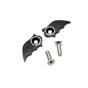 May include: Two black bat-shaped bike frame protectors with the text "Kawaii Kuwuma dr. Infamous" on each. Two silver screws are included.