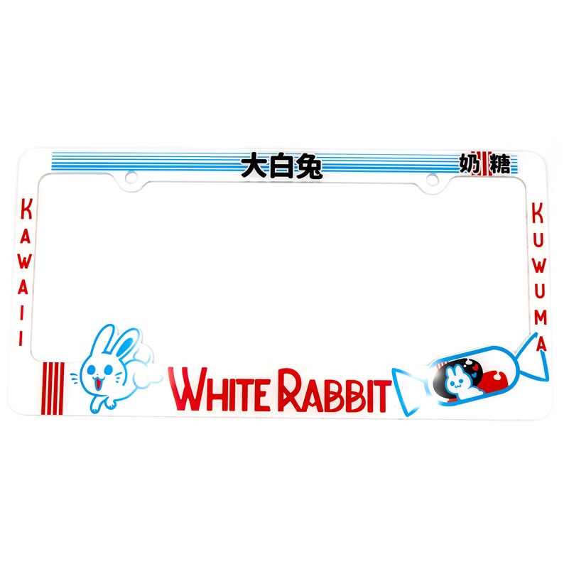 以下が含まれることがあります： 白いナンバープレートフレーム。赤い「White Rabbit」の文字と漫画のウサギが描かれています。フレーム上部には青いストライプと日本語の文字、側面には赤い「Kawaii」と「Kuwuma」の文字があります。