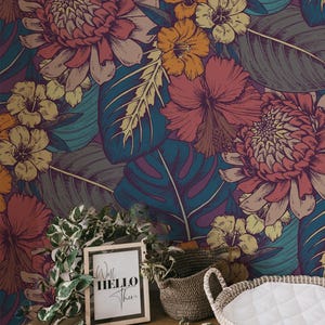 May include: A colourful floral wallpaper design with large flowers in pink, orange, and yellow, set against teal and purple leaves. A framed sign reads "Well Hello There".