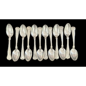 May include: A collection of silver spoons arranged against a black background. The spoons have an oval bowl and ornate detailing on the handles. The spoons are reflective, showing the light.