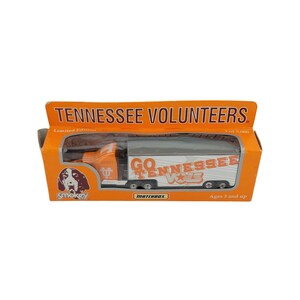 May include: Orange and white toy semi-truck with "GO TENNESSEE VOLS" text on the trailer. The truck is in a box with "TENNESSEE VOLUNTEERS" text. The box also features a dog illustration and the Matchbox logo.