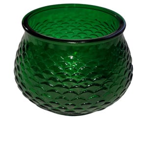 May include: A green glass bowl with a textured, scale-like pattern. The bowl is round and has a wide opening.