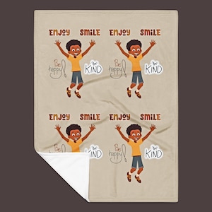 May include: A beige blanket featuring a repeating pattern of a cartoon boy jumping with arms raised. The words "ENJOY SMILE" are above each boy. The phrases "Be happy" and "Be KIND" are also included.
