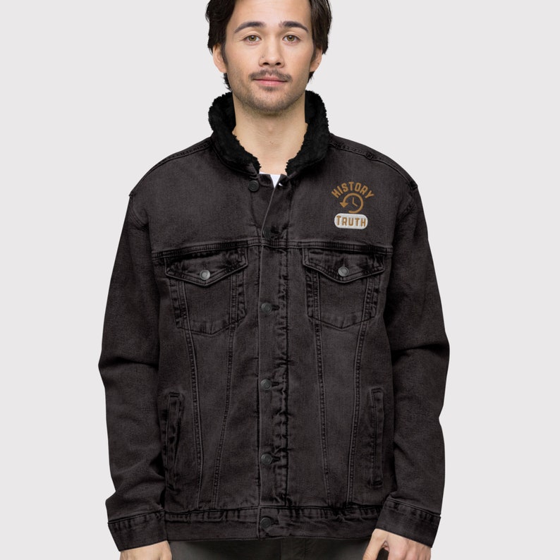 May include: Black denim jacket with a black faux fur collar. The jacket has a button-up front, pockets, and the words "HISTORY TRUTH" in a circular design on the upper left chest.