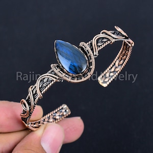 Peut inclure: Un bracelet en fil de cuivre enroulé avec une pierre précieuse en labradorite bleue. Le bracelet est réalisé avec un design de fil tressé.