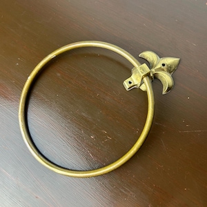 Peut inclure: Un anneau de serviette en métal doré avec un motif décoratif de fleur de lys.