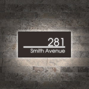 May include: A black house number sign with white lettering. The sign reads "281 Smith Avenue".