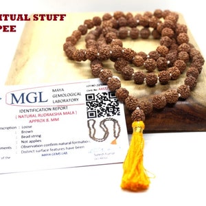 Puede incluir: Un collar de cuentas Rudraksha marrón con una borla amarilla, presentado con un informe de identificación del Maya Gemological Laboratory. Las cuentas del collar tienen aproximadamente 8 mm de diámetro. El texto "SPIRITUAL STUFF SHOPEE" es visible.