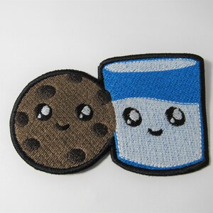 May include: Embroidered patch featuring a brown chocolate chip cookie and a blue and white milk carton, both with smiling faces and large eyes.