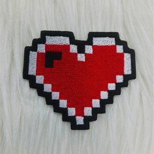 May include: A red pixelated heart embroidered patch with a white outline and black border.