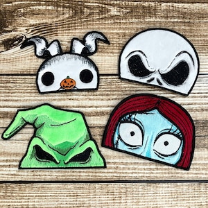 May include: Four embroidered patches featuring characters from the Nightmare Before Christmas. The patches are white, green, blue, and red. The characters are Jack Skellington, Oogie Boogie, Sally, and Zero.