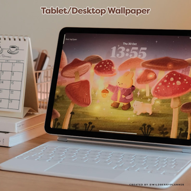 May include: A tablet with a white keyboard displaying a whimsical wallpaper featuring a cartoon rabbit and cat in a mushroom forest. The screen shows the date and time. Text at the top reads "Tablet/Desktop Wallpaper".