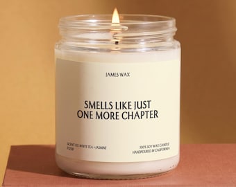 May include: A clear glass jar candle with a lit wick and white wax. The cream-colored label features the text JAMES WAX, SMELLS LIKE JUST ONE MORE CHAPTER, SCENT 03 WHITE TEA + JASMINE, F1238, and 100% SOY WAX CANDLE HANDPOURED IN CALIFORNIA.