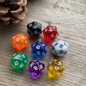 May include: Seven multi-coloured twenty-sided dice with white numbers. The dice are made of clear plastic and have a variety of colours, including red, orange, yellow, green, blue, purple, and black.