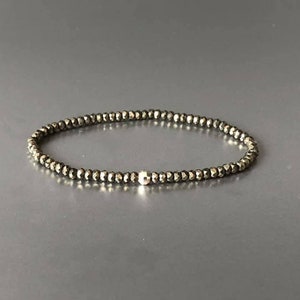 May include: A delicate bracelet made of small, faceted pyrite beads with a silver bead accent.