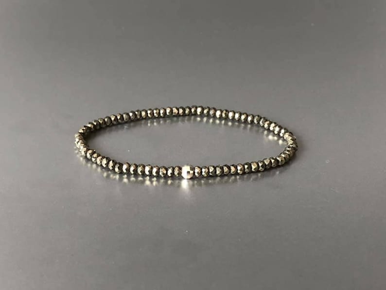 May include: A delicate bracelet made of small, faceted pyrite beads with a silver bead accent.