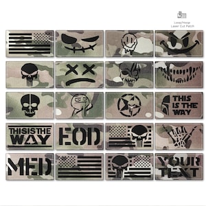 May include: A collection of camouflage-patterned patches with various designs. The patches feature images of skulls, smiley faces, and the American flag. Some patches have text, including "THIS IS THE WAY" and "EOD".
