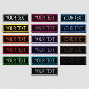 Op de afbeelding: Een verzameling van dertien rechthoekige geborduurde patches met zwarte achtergronden en randen. Elke patch bevat de tekst "YOUR TEXT" in een andere draadkleur, waaronder wit, geel, oranje, rood, groen, roze, paars, lichtblauw en zwart.