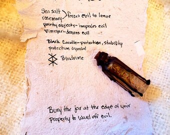May include: A handwritten recipe for a witch's bottle, a traditional folk magic charm. The recipe includes ingredients like sea salt, rosemary, pointy objects, vinegar, and a black candle. The recipe also includes a bindrune symbol. The recipe instructs to bury the jar at the edge of your property to ward off evil.