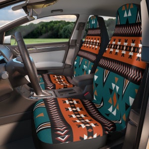Puede incluir: Fundas de asiento de coche con un patrón geométrico en verde azulado, naranja, negro y blanco. El diseño presenta triángulos, chevrones y otras formas dispuestas en bandas horizontales. Las fundas están instaladas en el interior de un coche.