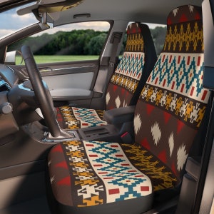 Puede incluir: Fundas de asiento de coche con un diseño de inspiración suroeste. Las fundas presentan un patrón repetitivo de formas geométricas en marrón, rojo, amarillo y turquesa. Las fundas están instaladas en el interior de un coche.