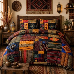 May include: A patchwork quilt and pillow set in a bedroom setting. The quilt features a variety of geometric patterns in shades of black, red, orange, and blue. The pillows have a similar design. The room is decorated with rustic wooden furniture and decorative lanterns.