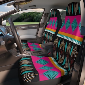 May include: Car seat covers with a vibrant geometric pattern in pink, turquoise, black, and orange. The design features diamond and triangle shapes, creating a Southwestern or tribal aesthetic. The covers are installed in a car interior.
