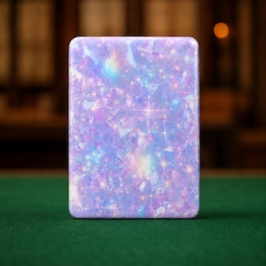 May include: A rectangular metal tin featuring a vibrant, iridescent pattern of light purple, blue, and pink crystalline shapes. The surface displays a shimmering, holographic effect with numerous small, bright star-like sparkles scattered throughout.