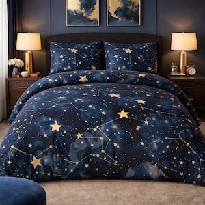May include: A navy blue duvet cover and pillow set with a gold star and constellation pattern. The bedroom features two bedside tables with lamps, and two framed paintings. The bedding set is designed to fit a double bed.