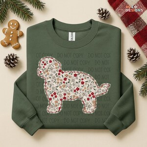 May include: Green sweatshirt featuring a floral dog design. The dog silhouette is filled with a pattern of red, white, and tan flowers. The sweatshirt has a crew neck and long sleeves. Festive holiday theme.