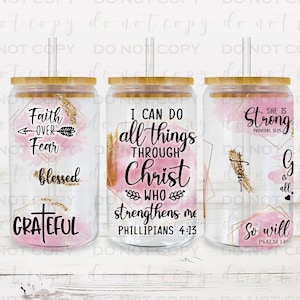May include: Three clear tumblers with pink and gold watercolor designs and inspirational quotes. The quotes are "Faith over Fear Blessed Grateful", "I can do all things through Christ who strengthens me Philippians 4:13", and "She is strong Proverbs 31:25 God is all So will I Psalm 148".