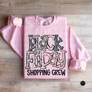May include: Pink crew neck sweatshirt with a black and white graphic print that says "Black Friday Shopping Crew".