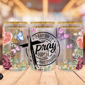 May include: Three clear glass tumblers with lids and straws. The tumblers have a floral design with butterflies and the text "Pray on it Pray over it Pray through".