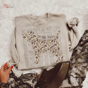 May include: A beige sweatshirt with a camouflage beagle silhouette. The text "beagle mom" is in the center, with "DO NOT COPY" and other phrases surrounding the dog. The sweatshirt is folded on a white surface.