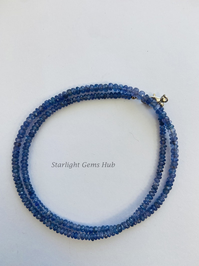 May include: A double strand necklace made of blue gemstone beads. The necklace has a silver clasp.