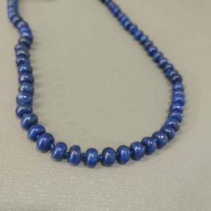 May include: A necklace made of dark blue lapis lazuli beads.