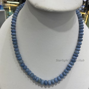 May include: A light blue gemstone necklace made of round beads. The necklace is displayed on a white mannequin bust. The text "Starlight Gems Hub" is visible in the lower right corner of the image.