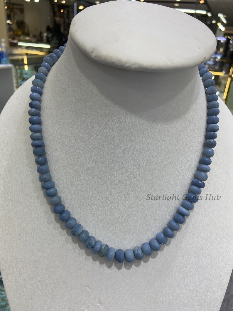May include: A light blue gemstone necklace made of round beads. The necklace is displayed on a white mannequin bust. The text "Starlight Gems Hub" is visible in the lower right corner of the image.